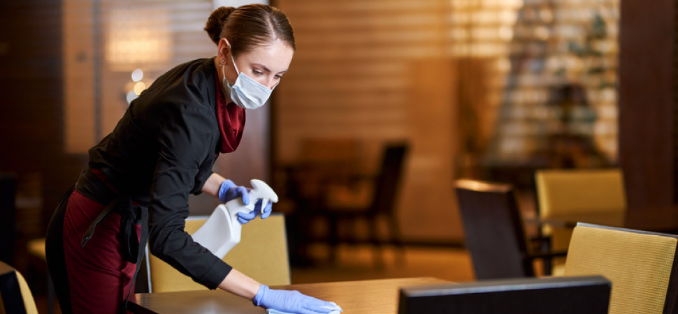 A lady cleaning a restaurant table